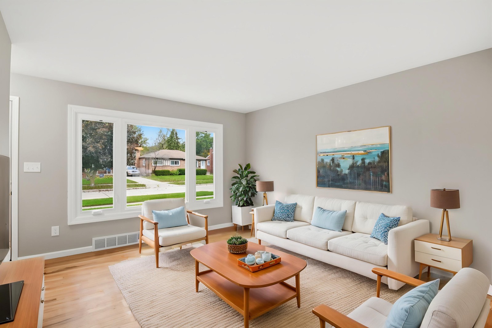 Virtually staged living room with a sofa, two chairs and a coffee table