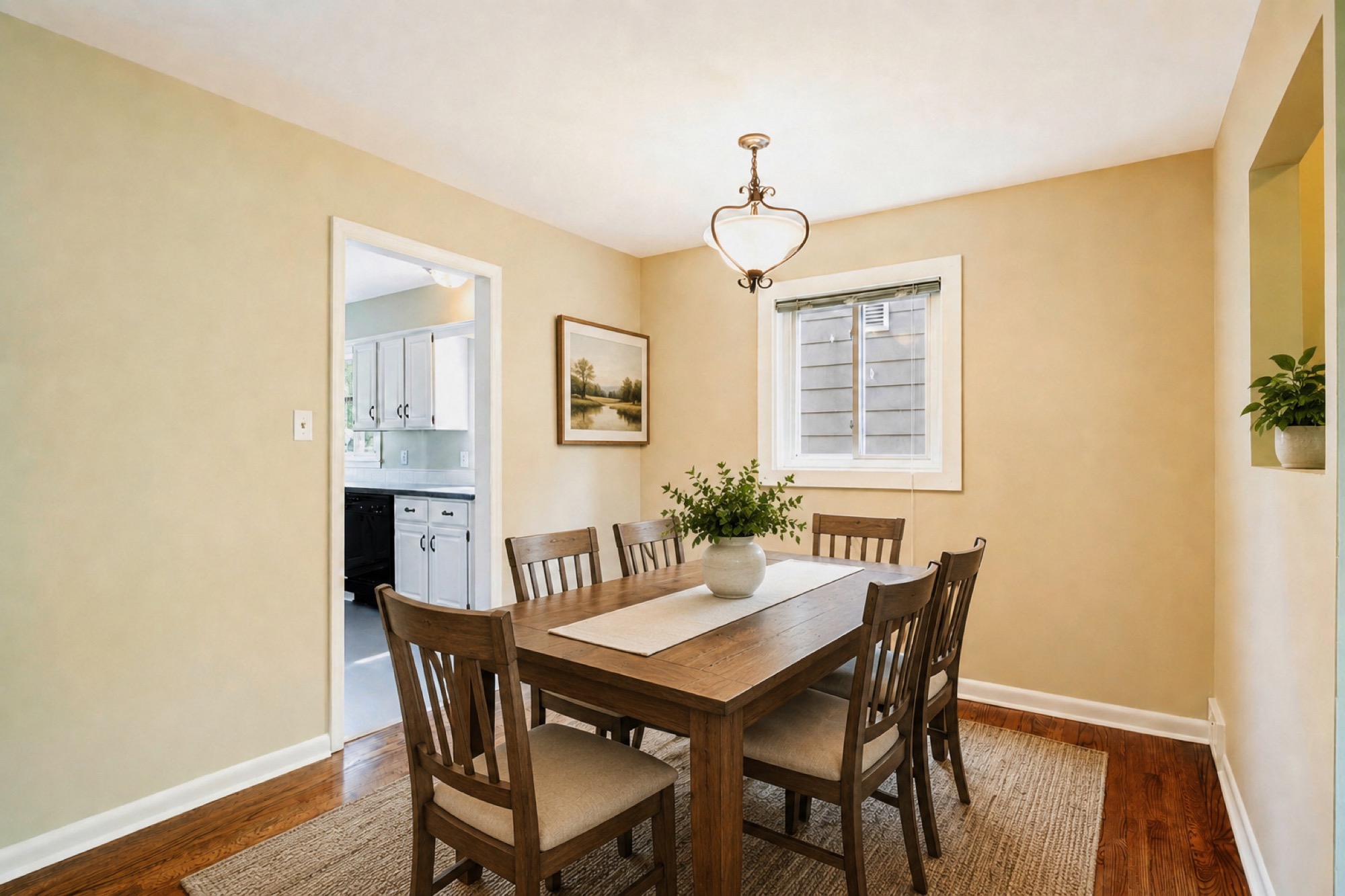 The same dining room virtually staged with a table, six chairs and artwork