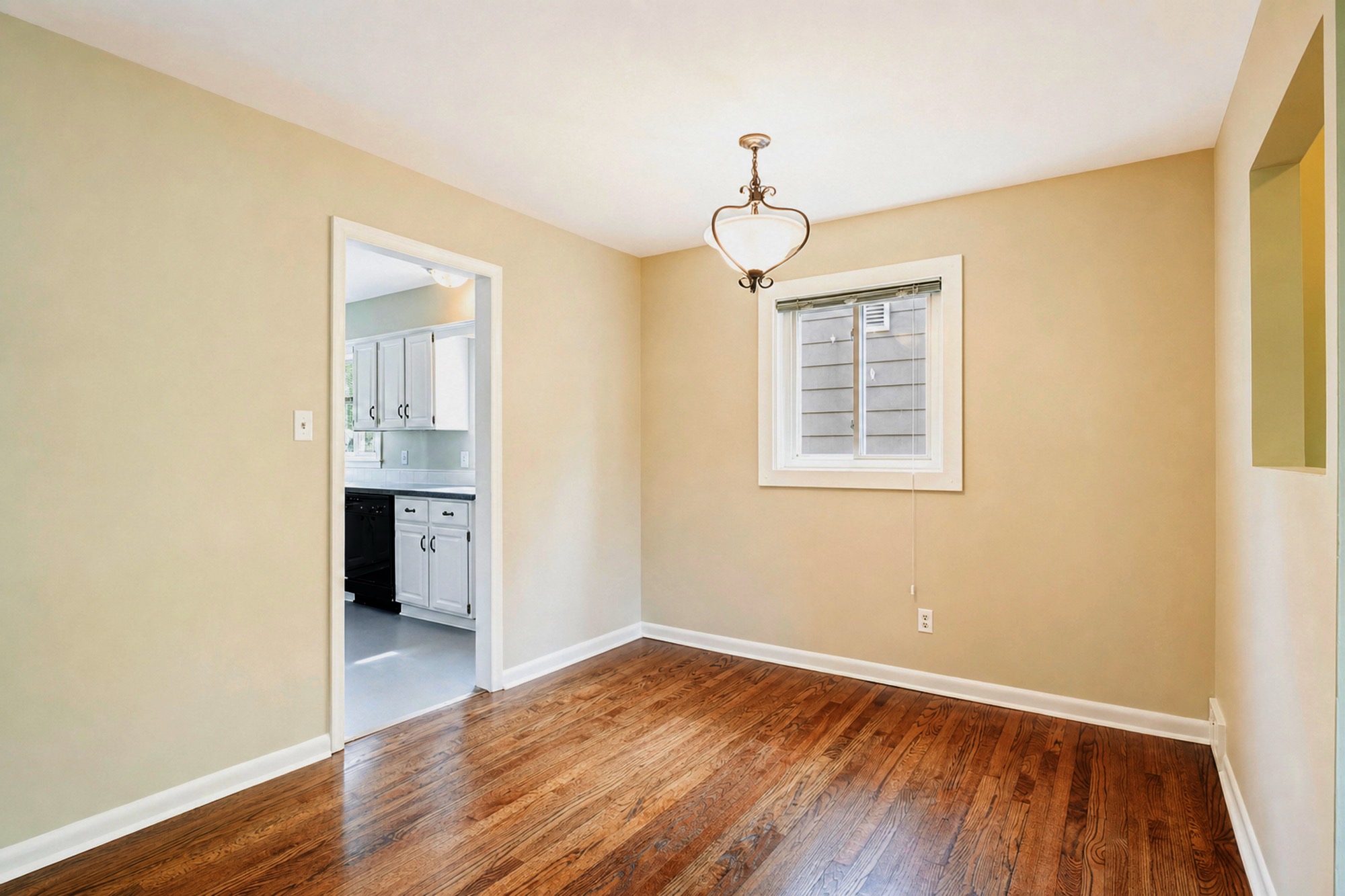 Empty dining room with a pendant light and a window