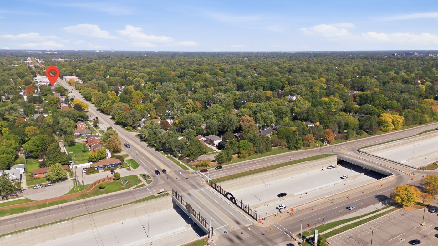Aerial photographs of commercial sites on busy Metro Detroit roads, with the property marked