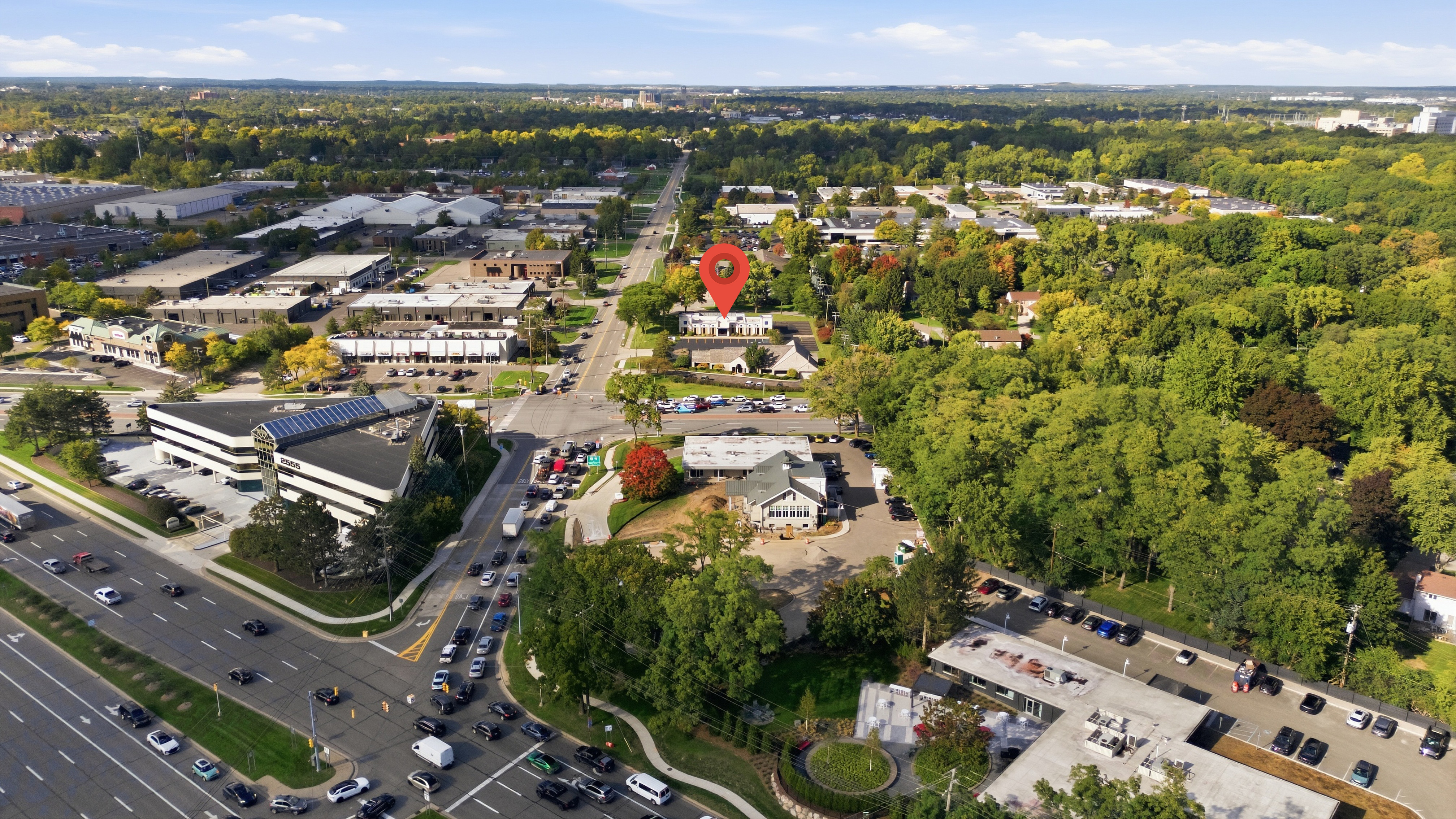 Aerial photograph of a Metro Detroit commercial corridor with traffic on the road