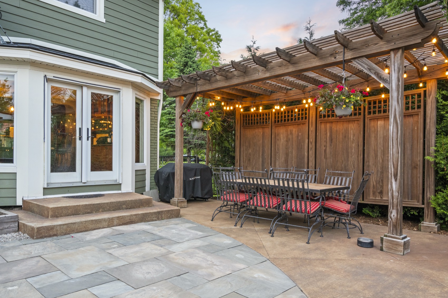 Patio and pergola photographed at dusk with the string lights on